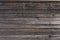 Surface of a heavily weathered planking of a facade made of wooden slats