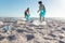 Surface level view of african american couple collecting garbage at beach on sunny day