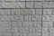Surface of light gray unpainted brick veneer wall