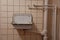Surface mounted water pipes and waste water pipes in tiled bathroom