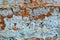 The surface of an old clay wall, weathered layers crumble, painted in different colors, for background or texture, an old house in