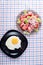 Surface of the table with a black plate with a fried egg and a t