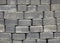 The surface of a wall or fence lined with gray bricks. Paving slabs of grey blocks of flat shape. Pavement blocks
