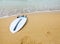 Surfboard lying on sand near the ocean