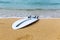 Surfboard lying on sand near the ocean