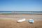 Surfboards standing upright in bright sun on the empty beach/Surf boards on the sand of an empty beach