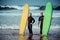 Surfer beginner and instructor on a beach with a surfboards