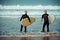 Surfer beginner and instructor on a beach with a surfboards