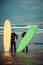 Surfer beginner and instructor on a beach with a surfing boards