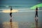 Surfer beginner and instructor on a beach with a surfing boards