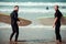 Surfer beginner and instructor on a beach with a surfing boards