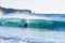 Surfer on Blue & green Ocean Wave riding a surfboard