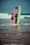 Surfer couple on the beach with a surfing board