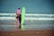 Surfer couple on the beach with a surfing board