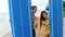 Surfer couple waving hand saying hello posing with surfboard on beach