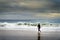 A surfer entering the sea at the Carcavelos Beach in Oeiras