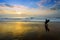 Surfer entering water at sunset