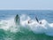 Surfer falling off his board into wave