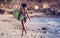 Surfer girl with afro hairstyle walking with surfboard