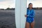 Surfer Girl. Beautiful Surfing Woman On Ocean Beach. Brunette In Blue Wetsuit Standing Near White Surfboard After Surf.