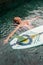 Surfer girl with longboard in pool