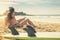 Surfer girl lying on the beach and watching to the ocean