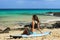 Surfer girl sitting on surfboard at beach