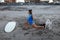 Surfer Girl. Surfing Woman Stretching On Sandy Beach. Asian Brunette In Blue Wetsuit With Surfboard And Dog.