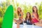 Surfer girls group holding happy surfboards on convertible car