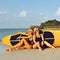 Surfer girls posing with surfboard on a beach