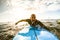 Surfer guy paddling with surfboard at sunset in Tenerife