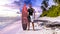 Surfer guy on a tropical beach at sunset