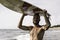 Surfer holding his surfboard on the head - Hipster man standing on the beach and waiting big waves for surfing - Fit bearded man