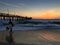 Surfer at Imperial Beach in San Diego, California lit by a stunning sunset