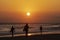 Surfer leaving the beach at sunset