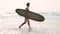 Surfer man walking on ocean coast.