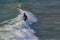 Surfer navigates the crest of a wave at Pismo Beach, California