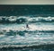 Surfer paddles out beyond the break at Stinson Beach, California