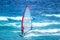 Surfer with red and blue sail