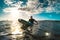 Surfer relaxing on surfboard at sunset in Tenerife waiting for the next good wave - Sport travel concept