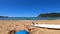 Surfer resting by his surfboard on the sand in Porto Ferro. Sardinia