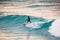 Surfer ride on red surfboard on blue wave. Winter surfing in ocean
