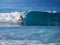 A surfer rides along a big beautiful glassy wave.