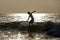 A surfer rides a wave at the point break at Arugam Bay in Sri Lanka at sunrise.