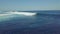 Surfer riding and turning with spray on powerful ocean wave.