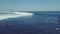 Surfer riding and turning with spray on powerful ocean wave.