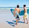 Surfer, running and rear view of men friends at a beach with freedom, energy or fun. Back, fitness and surfing people at