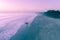 Surfer silhouette entering the ocean water at sunrise.