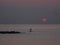 Surfer silhouette in front of sun at sunrise