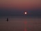 Surfer silhouette in front of sun at sunrise